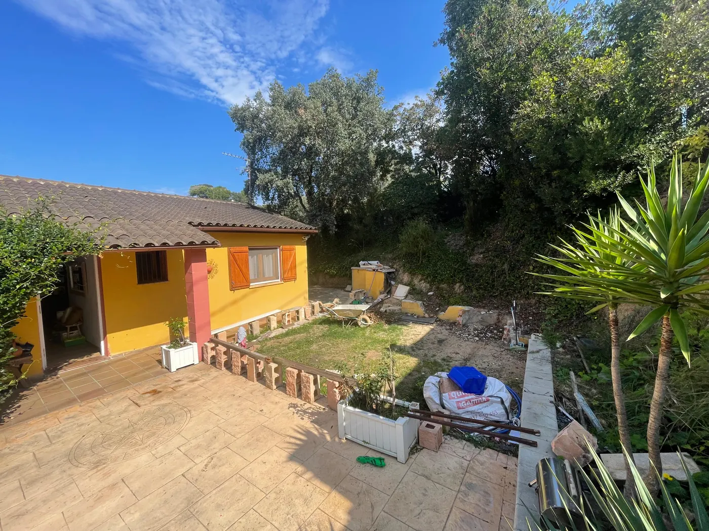 Patio de vivienda antes de la ampliación, con el terreno sin urbanizar, en Girona