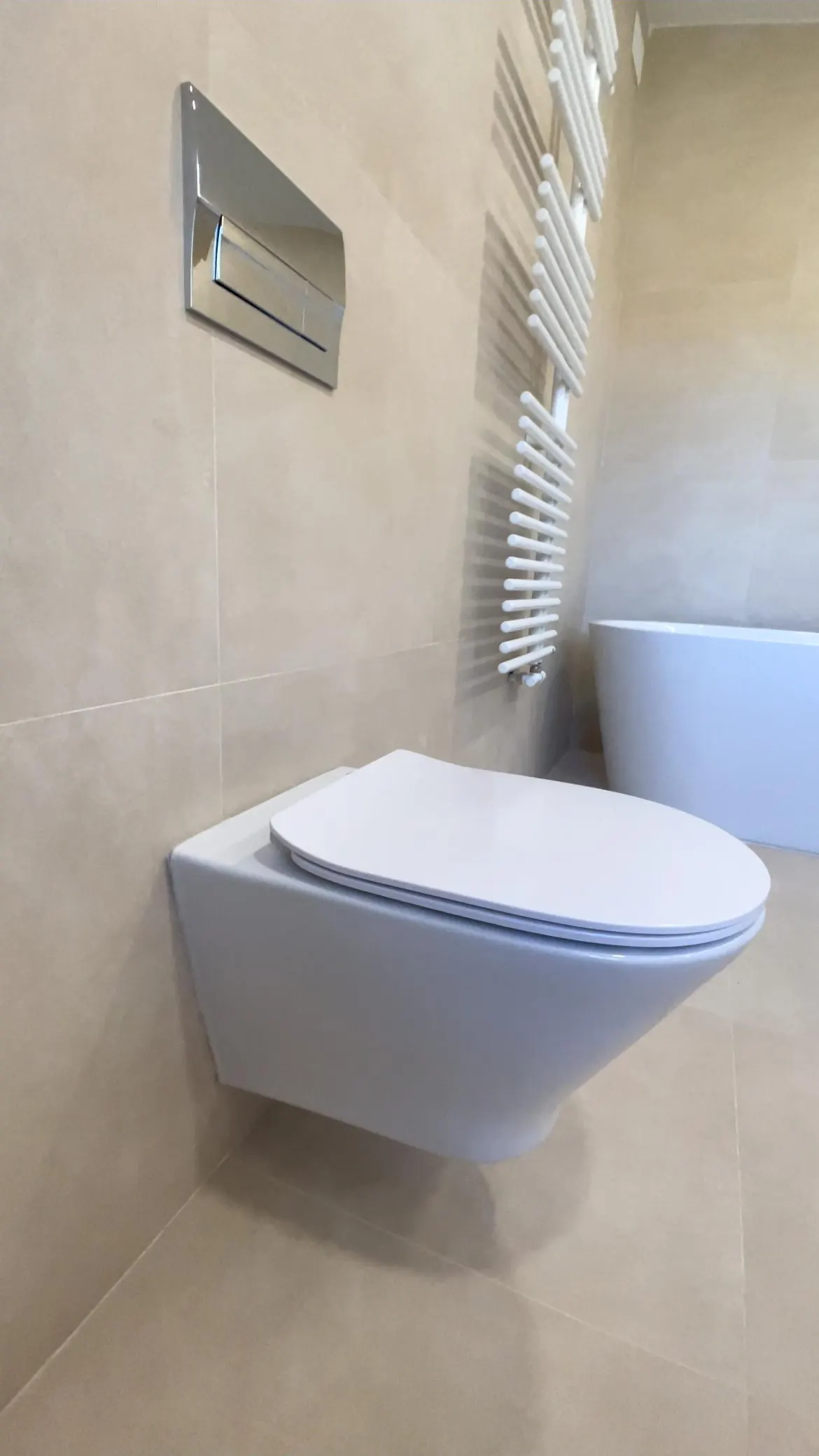 Baño reformado con inodoro suspendido, toallero y bañera exenta, obra de Gasparini Construcciones