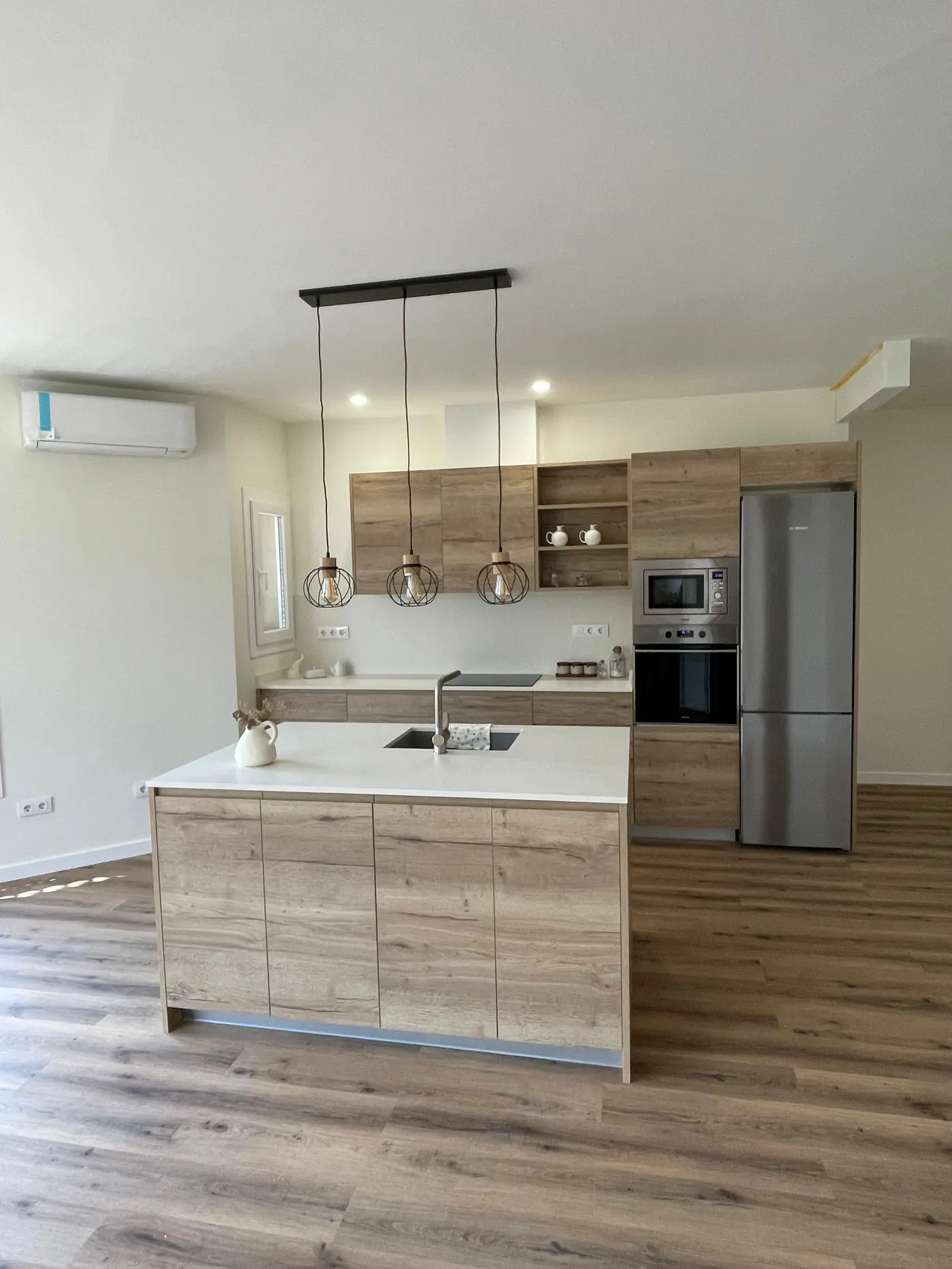 Cocina reformada por Gasparini Construcciones, con isla y electrodomésticos integrados