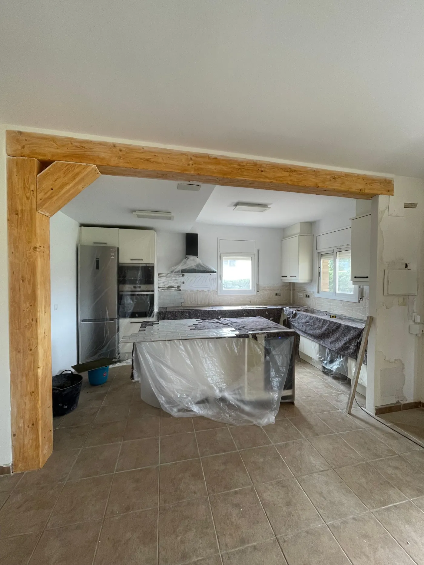 Reforma de cocina en curso, con viga de madera vista, obra de Gasparini Construcciones